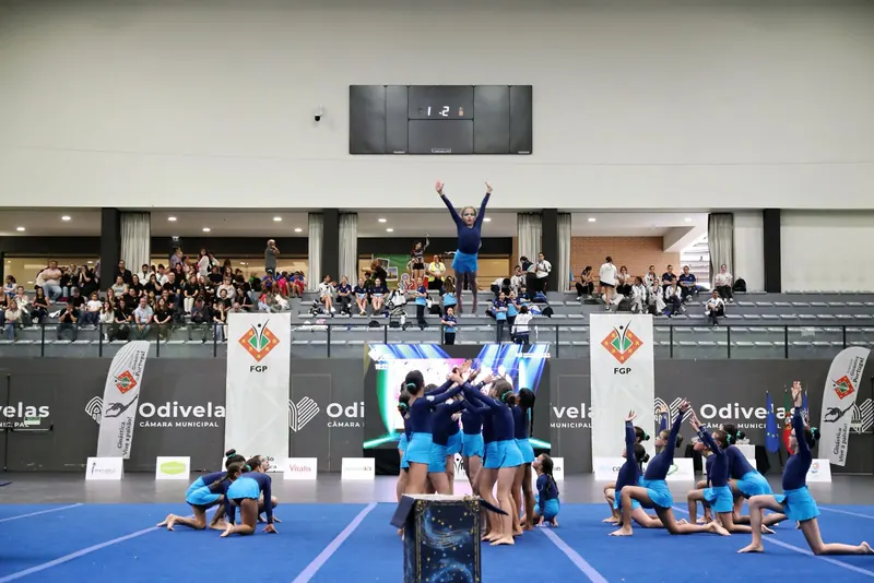 Atleta de pé no topo de uma figura de grupo, em exibição